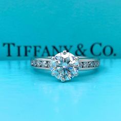 Tiffany & Co Channel Set Platinum Diamond Engagement Ring Style: Tiffany Setting with Channel-set Diamond Band Ref. number: 23177803 / I5080346 Metal: Platinum Size: 6 - sizable TCW: 1.91 tcw Main Diamond: Round Brilliant Cut Diamond 1.56 cts Color & Clarity: G - VS2 / EX EX EX Cut Accent Diamonds: 10 Round Brilliant Cut Diamonds. 0.35 tcw Color & Clarity: F - G / VS Hallmark: ©TIFFANY&CO. PT950 13177803 1.56CT Includes: T&C Diamond Certificate - T&C Original Appraisal - T&C Inner & Outer Boxes Retail Value: $39,000 Sku#133150TSTADEN021121-6 Return Policy: Returns accepted up to 14 days. Payment Information: We accept payment by PayPal International Buyers: Buyer is responsible for any customs fees or duties incurred by their country based on their country's rules & regulation no exception Channel Set Diamond Band, Tiffany Setting, Diamond Band Engagement Ring, Diamond Engagement Band, Platinum Diamond Engagement Rings, Band Engagement Ring, Engagement Ring Styles, Channel Set, Ring Style