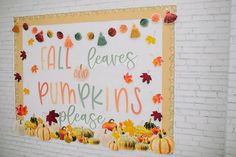 a white brick wall with a sign that says fall leaves and pumpkins please on it