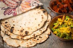 several different types of food in bowls on a metal tray, including pita bread and broccoli