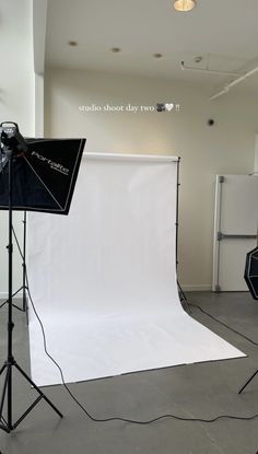 an empty photo studio with white backdrops and lighting equipment in front of the camera