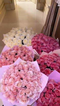 a bunch of flowers that are in some kind of vase on a table with pink and white roses