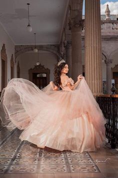 a woman in a pink dress is posing for the camera with her long flowing skirt