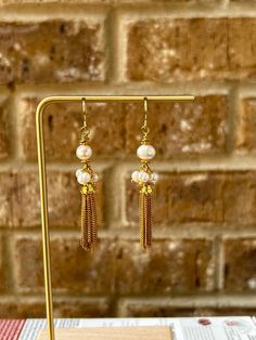 Elegant gold tone tassel earrings with clusters of pearls that are wire wrapped. Great for an evening out. Gold Pearl Drop Tassel Earrings For Party, Gold Tassel Earrings With Pearl Drop For Party, Elegant Pearl Drop Dangle Tassel Earrings, Elegant Pearl Drop Tassel Earrings For Party, Party Tassel Pearl Drop Earrings, Party Tassel Drop Earrings With Pearl Detail, Elegant Beaded Dangle Earrings With Tassels, Gold Pearl Earrings With Dangling Beads For Party, Gold Beaded Earrings With Pearl Drop For Party