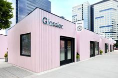 a pink building with the word glosser on it's side in front of some tall buildings