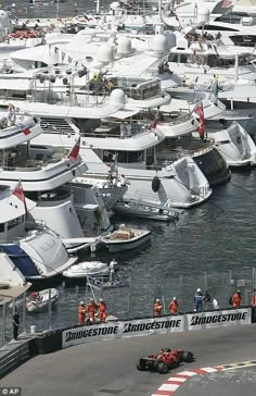 many boats are docked in the water at a boat show with people standing around them