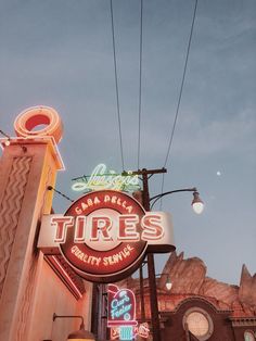 there is a neon sign on the side of this building that says tires city service