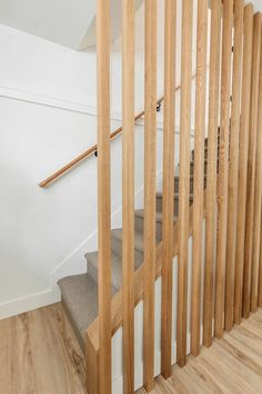 an empty staircase with wooden handrails and white walls