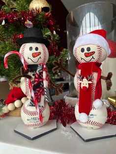 two baseball themed snowmen sitting on top of a table next to a christmas tree