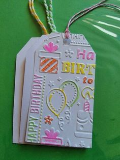 a birthday tag hanging from a string on a green surface