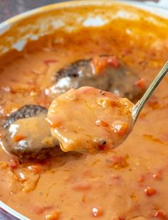 a spoon full of soup with meatballs and gravy