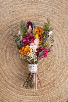 a bunch of flowers sitting on top of a jute flooring area with rope