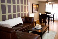 a living room filled with furniture and a dining area in the back drop down wall