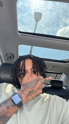 a man with dreadlocks sitting in the back seat of a car