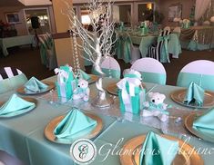 the table is set for a baby shower party with blue and white decorations on it