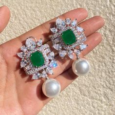 Emerald Earrings featuring semi precious greenstone with white pearls and cz diamond. Ideal to pair with any party outfit or your bridal wedding gown. These earrings are surely elevate your look. Perfect gift for Her. *𝐏𝐑𝐎𝐃𝐔𝐂𝐓 𝐃𝐄𝐓𝐀𝐈𝐋* * 𝐌𝐚𝐭𝐞𝐫𝐢𝐚𝐥: Brass * 𝐏𝐥𝐚𝐭𝐢𝐧𝐠: White Rhodium Plated * 𝐒𝐭𝐨𝐧𝐞: AAA-quality CZ Diamond, Emerald & Pearl. *𝐃𝐈𝐌𝐄𝐍𝐒𝐈𝐎𝐍𝐒* * 𝐖𝐞𝐢𝐠𝐡𝐭: 14 gm each * 𝐋𝐞𝐧𝐠𝐭𝐡: 2 Inches * 𝐖𝐢𝐝𝐭𝐡:  1.5 mm * 𝐂𝐥𝐨𝐬𝐮𝐫𝐞: Push Back 𝐕𝐢𝐬𝐢𝐭 𝐎𝐮𝐫 𝐅𝐀𝐐𝐬 𝐟𝐨𝐫 𝐒𝐡𝐢𝐩𝐩𝐢𝐧𝐠 𝐏𝐨𝐥𝐢𝐜𝐢𝐞𝐬 𝐚𝐧𝐝 𝐂𝐚𝐫𝐞 𝐈𝐧𝐬𝐭𝐫𝐮𝐜𝐭𝐢𝐨𝐧 *𝐃𝐈𝐒𝐂𝐋𝐀𝐈𝐌𝐄𝐑* * Product color may slightly vary due to photographic lighting sources or your screen settings. * Stone color may vary slightly due to variations in natural stones. *𝐒𝐈𝐌𝐈𝐋? Exquisite Emerald Earrings For Wedding, Exquisite Green Diamond Earrings For Wedding, Exquisite Green Diamond Wedding Earrings, Exquisite Emerald Wedding Earrings, Green Gemstone Bridal Earrings For Wedding, Green Diamond Bridal Earrings Fine Jewelry, Green Drop Diamond Earrings For Wedding, Green Diamond Drop Earrings For Bridal, Green Diamond Drop Bridal Earrings