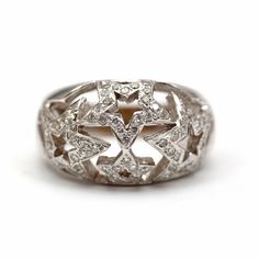 a white gold ring with diamonds in the center and an intricate design on the side