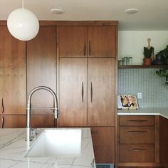 a kitchen with wooden cabinets and a white sink in front of a counter top oven