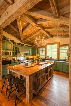 a large kitchen with wooden floors and green cabinetry on the walls, along with two bar stools