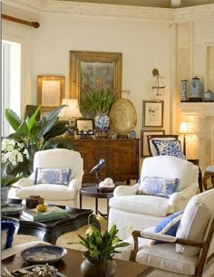 a living room filled with white furniture and lots of pillows on top of it's couches