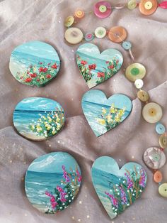 several heart shaped buttons with flowers painted on them