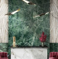 an elegant living room with green marble walls and red velvet chairs in front of the fireplace