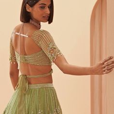 Muted jade green lehenga embellished with pearl and glass floral motifs teamed with a modern blouse with geometric embroidery and and strappy tie back. Includes an organza dupatta. Composition: Organza Care: Dry Clean Only and Vacuum Storage This product can be customised for sleeves, length of blouse and neckline Delivery : 4-6 weeks as the product is hand crafted. For more information and sizes please contact fabiliciousfashion@gmail.com or visit our Copenhagen studio.About the Designer : Paru Long Kurti Patterns, Modern Blouse, Modern Bridal Gowns, Blouse Necklines, Wedding Lehenga Designs, Lehenga Blouse Designs, Green Lehenga, Vacuum Storage, Geometric Embroidery