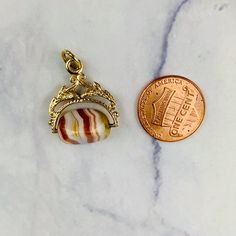 "This is a beautiful Victorian style Swivel Fob Seal / Pendant in 9K / 9ct yellow gold. The spinning fob pendant features hand carved floral gold design and a triangle shaped banded agate with vibrant white, red/orange, and yellow colors. The fob measures 0.87\" (22.3mm) high including bail without split ring and 0.76\" (19.4mm) wide at it is widest point. It is fully hallmarked for Birmingham Assay, 9ct gold, and year letter for 1977. It weighs 3.862 grams. All of our listings come in a box rea Yellow Gold Oval Agate Jewelry, Oval Agate Yellow Gold Jewelry, Oval Yellow Gold Agate Jewelry, Gold Agate Jewelry With Oval Cabochon, Gold Agate Oval Cabochon Jewelry, Elegant Miniature Jewelry For Collectors, Collectible Yellow Gold Jewelry With Oval Cabochon, Gold Agate Hallmarked Jewelry, Vintage Agate Oval Cabochon Jewelry