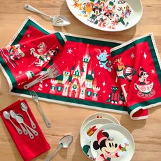 mickey mouse placemats, plates and utensils on a wooden table