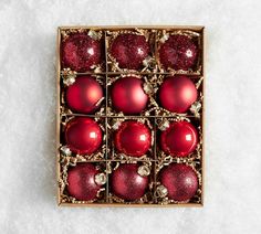 a box filled with red ornaments on top of a white surface