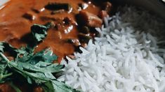 a bowl filled with rice and meat next to green leafy garnishes