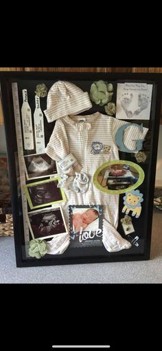 a baby's clothes and other items are displayed in a shadow box