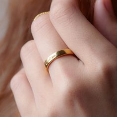 a close up of a person wearing a gold ring