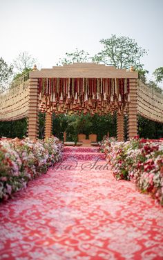 an outdoor ceremony with red carpet and flowers