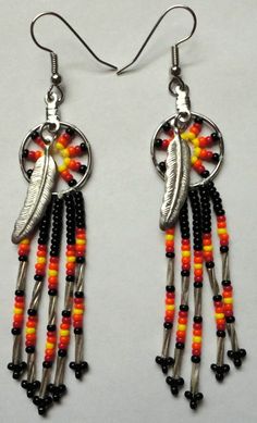 two pairs of earrings with beads and feathers hanging from it's earwires