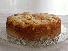 a cake sitting on top of a glass platter next to a white tablecloth