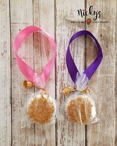 two bags of food sitting on top of a wooden table next to each other with ribbons around them