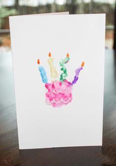 a birthday card with the number four painted on it and candles in the shape of a hand