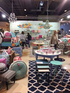 a room filled with lots of different colored furniture and decor items on display in front of people