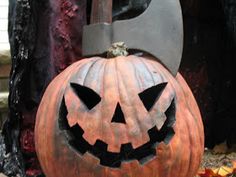 a carved pumpkin sitting on top of a pile of leaves