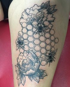 a woman's thigh with flowers and honeycombs tattoo on her leg,