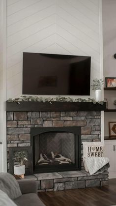 a living room with a fireplace and television on top of the mantel in front of it