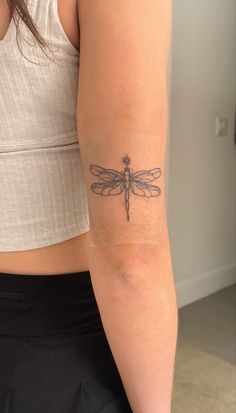 a woman with a dragonfly tattoo on her arm