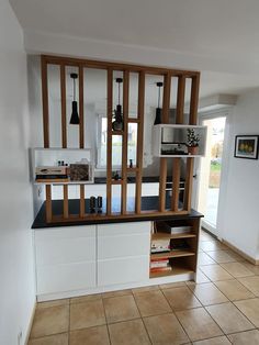 a kitchen with tiled flooring and white cabinets in the center, open shelving