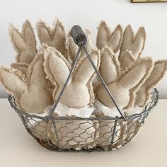 a wire basket filled with burlap flowers on top of a table