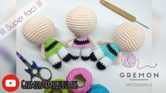 three crocheted dolls sitting on top of a table next to yarn and scissors