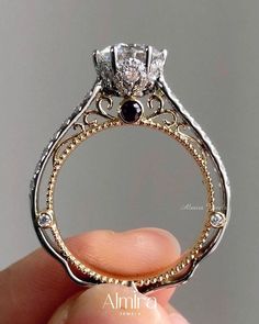 a close up of a person holding a ring with a diamond on it's side