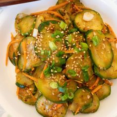 a white plate topped with cucumbers and sesame seeds