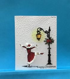 a christmas card with an image of a woman holding a lamp post