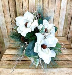 a bouquet of white flowers sitting on top of a wooden table