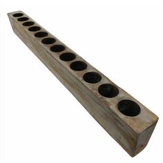 an old wooden block with holes in the center and four holes on each side, all lined up